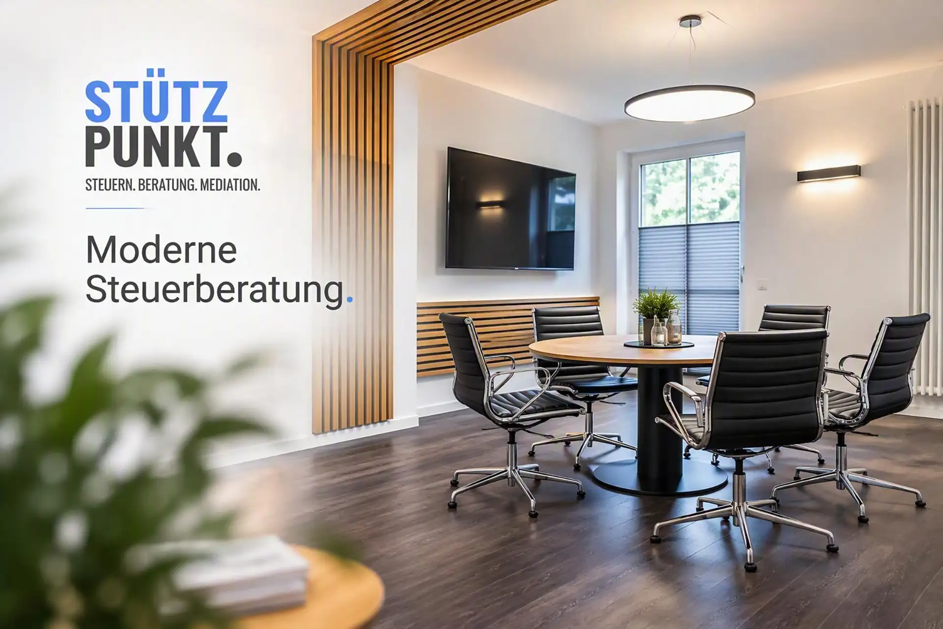 Großer Büroraum mit rundem Besprechungstisch und Stühlen in angenehm beleuchtetem Ambiente. Das Logo Stützpunkt mit dem Claim "Moderne Steuerberatung." ist links im Bild zu sehen.